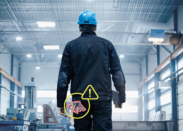 Rückansicht eines Facility Managers mit Schlüsselbund, der durch eine Hall läuft