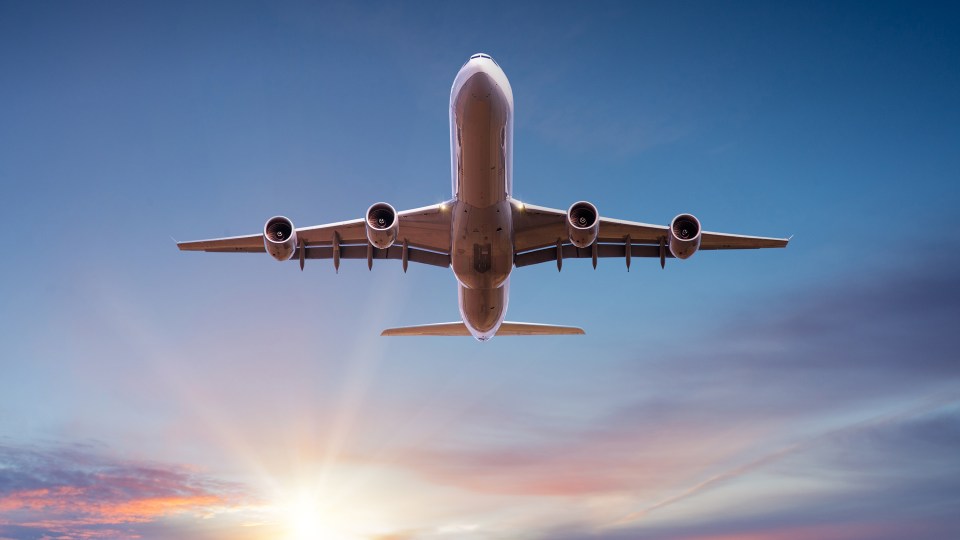 Flugzeug liegt über Wolken bei Sonnenuntergang