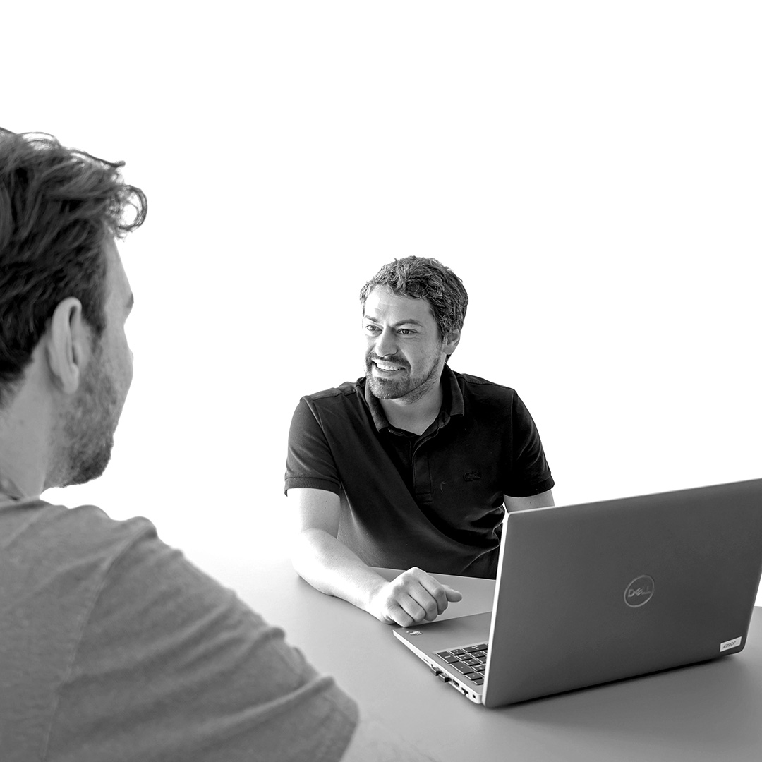 Interflex-Mitarbeiter am Laptop im Gespräch im Büro