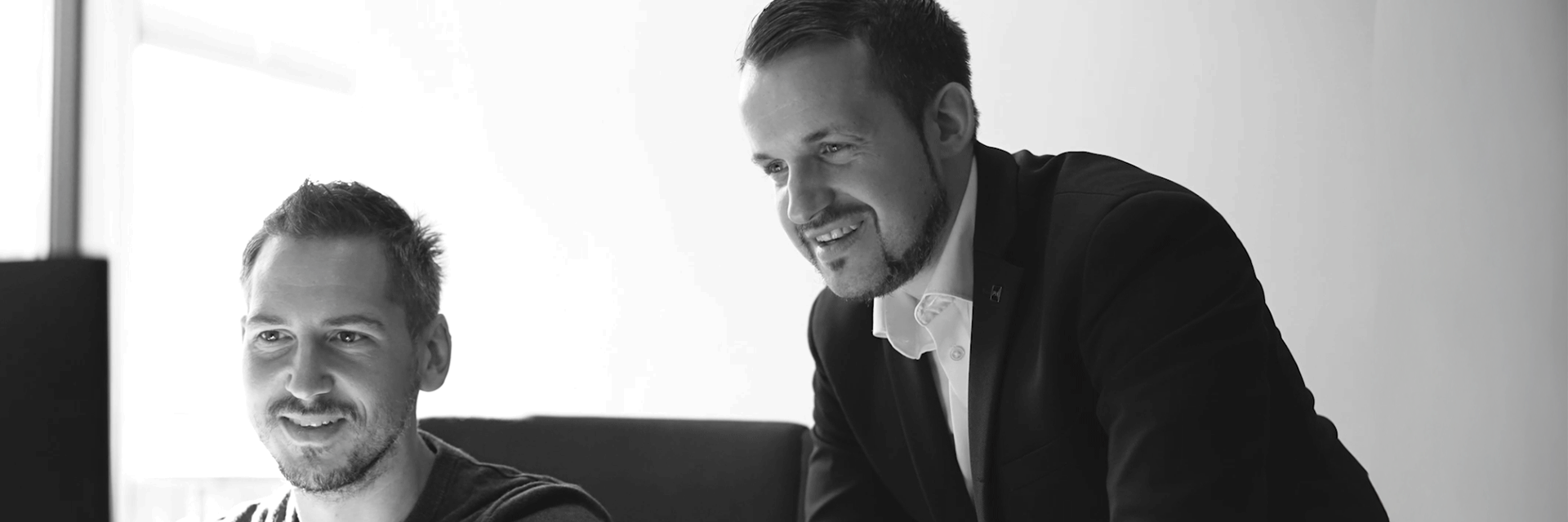2 Mitarbeiter arbeiten gemeinsam am Bildschirm.