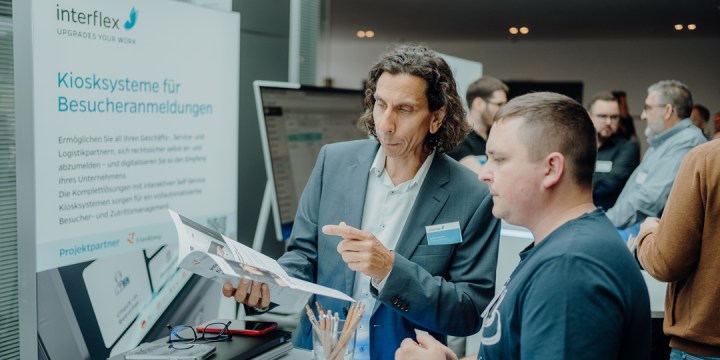 Interflex-Mitarbeiter erklärt Interessenten auf dem Customer Solution Day Kiosksysteme für das Besuchermanagement