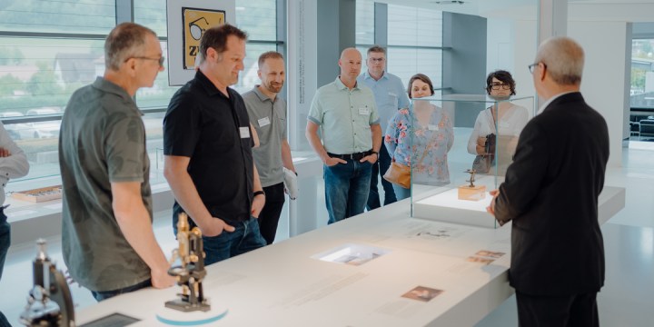 Personengruppe nimmt an Betriebsbesichtigung bei Carl Zeiss teil