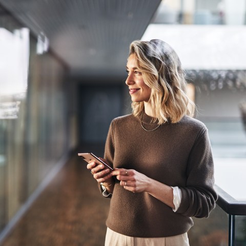 Woman smiling and holding a smartphone