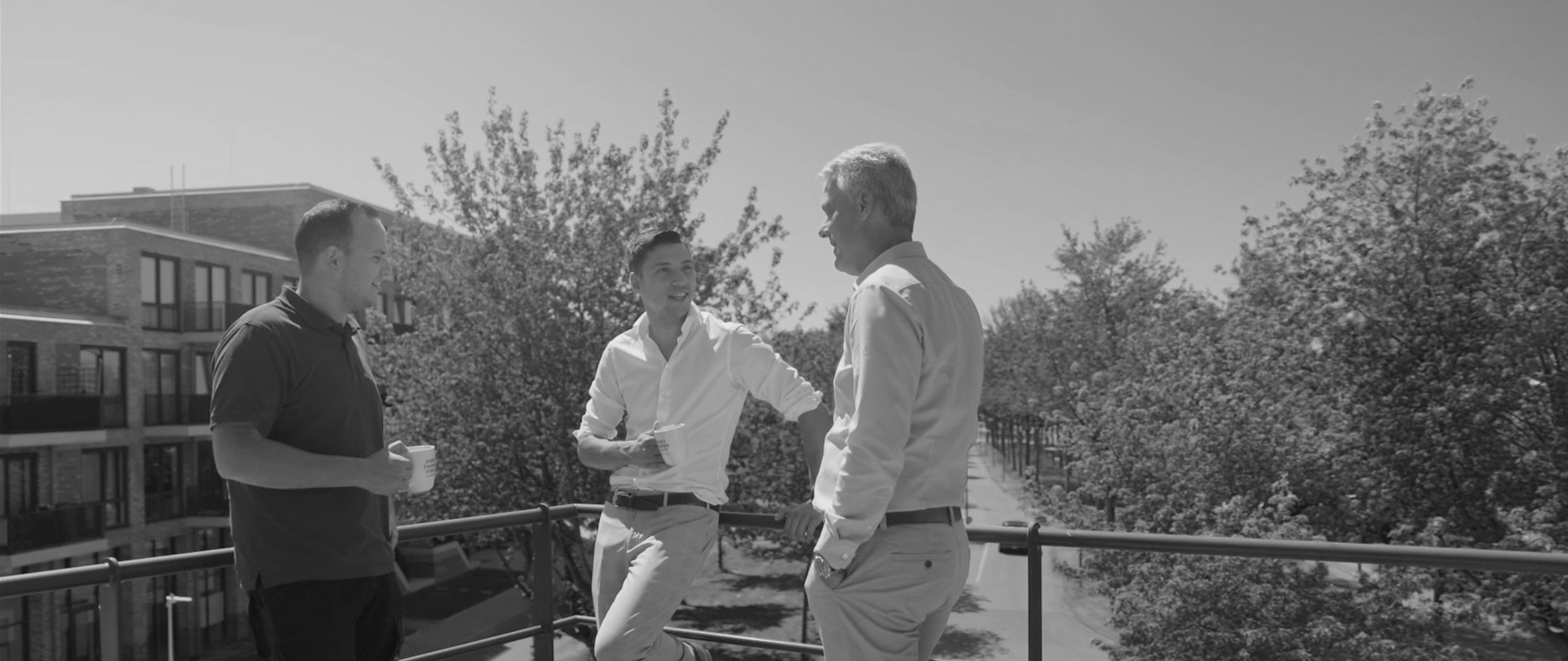 Drie mannen die op het terras aan het praten zijn tijdens een pauze.