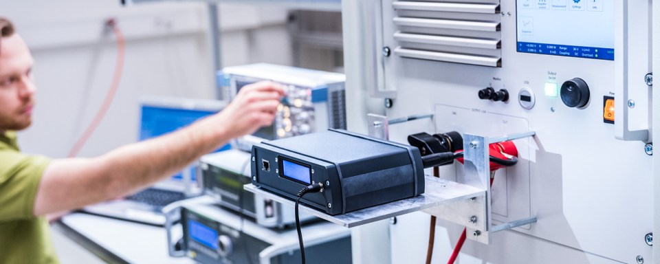 Technicien testant des appareils électroniques dans un laboratoire sur un banc d'essai